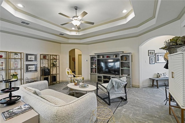 living room featuring crown molding, ceiling fan, and a raised ceiling