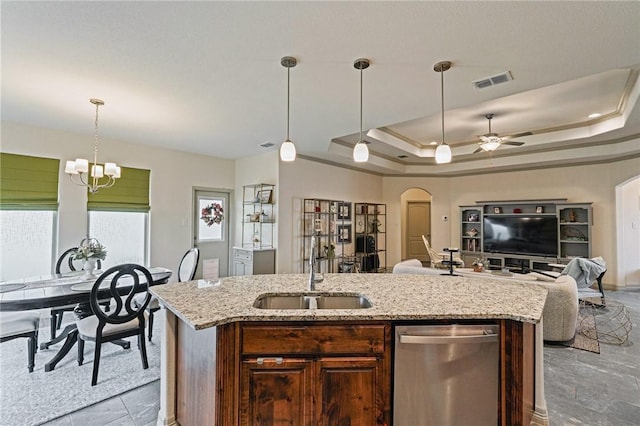 kitchen with sink, a raised ceiling, dishwasher, and a center island with sink