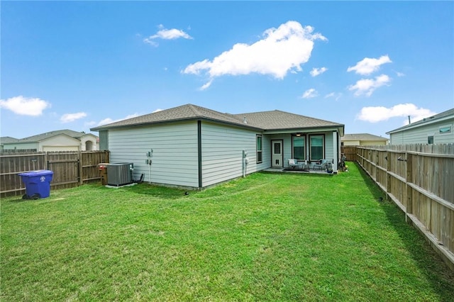 rear view of property with a yard and central AC