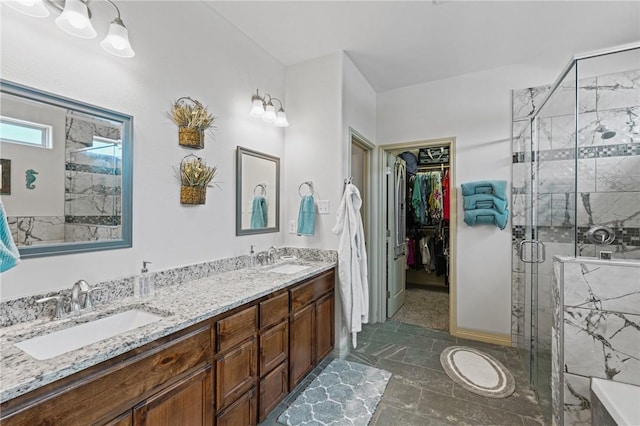 bathroom featuring a shower with door and vanity