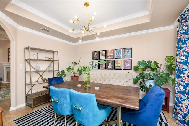 dining area with a chandelier, light tile patterned floors, a raised ceiling, and crown molding