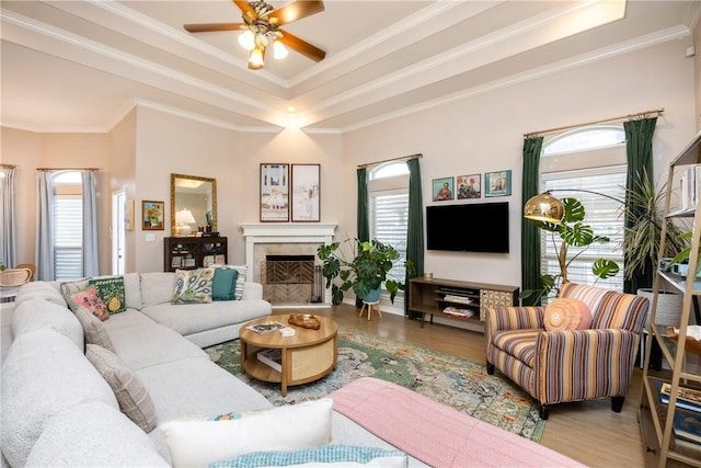 living room with light wood-type flooring, ceiling fan, and crown molding