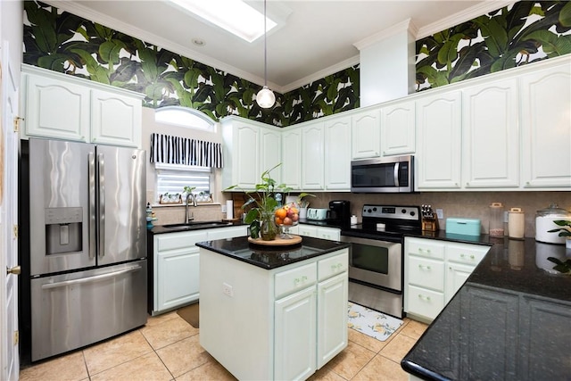 kitchen with white cabinets, sink, a kitchen island, and appliances with stainless steel finishes