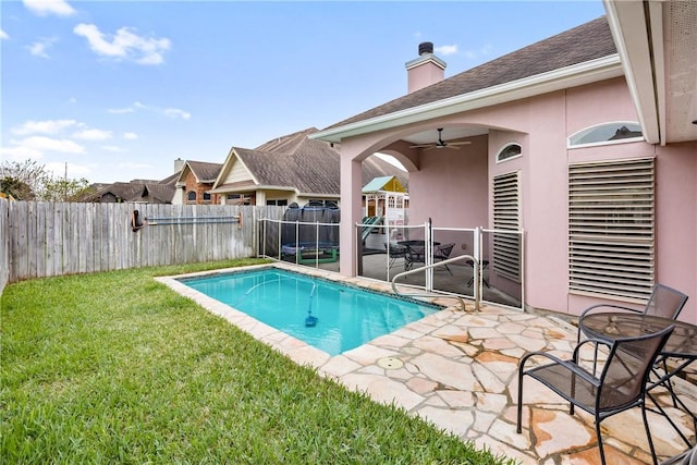 view of pool featuring ceiling fan, a yard, and a patio