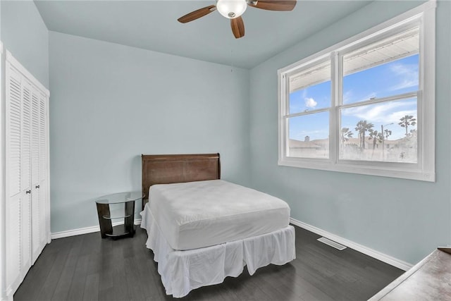 bedroom with visible vents, baseboards, dark wood-type flooring, and a ceiling fan