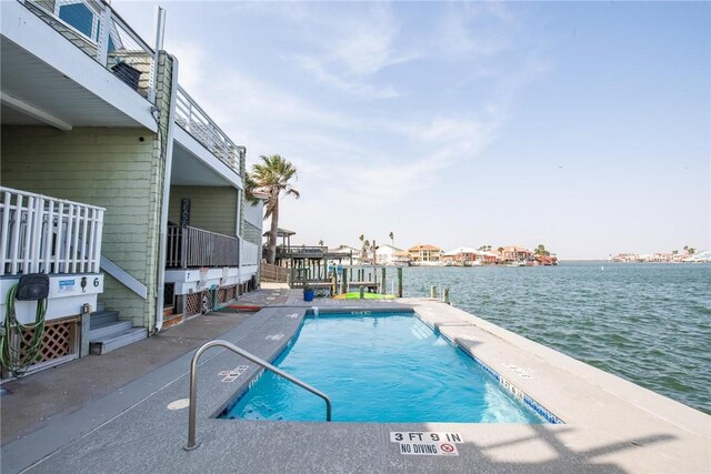 pool featuring a patio and a water view