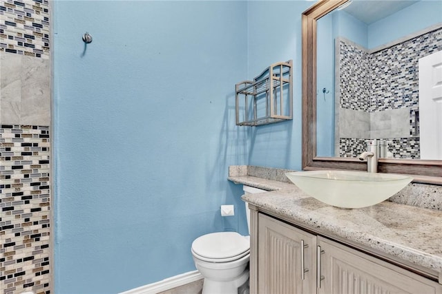 bathroom with vanity, toilet, and baseboards