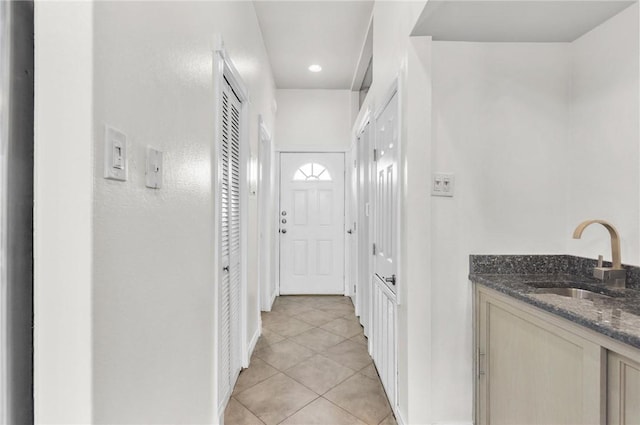 hallway with light tile patterned flooring and a sink