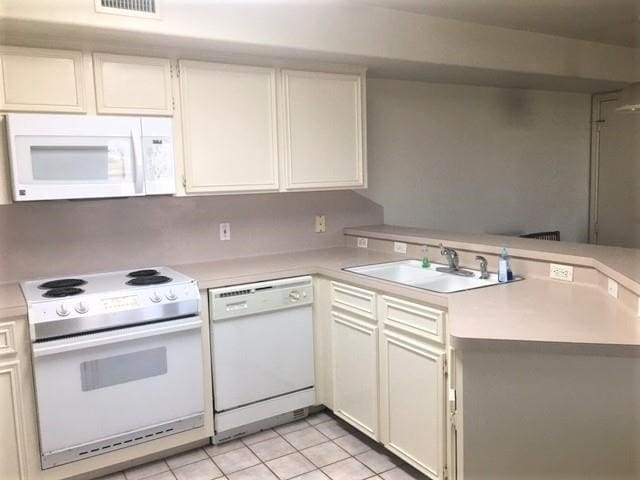 kitchen featuring white cabinets, sink, white appliances, and light tile patterned floors