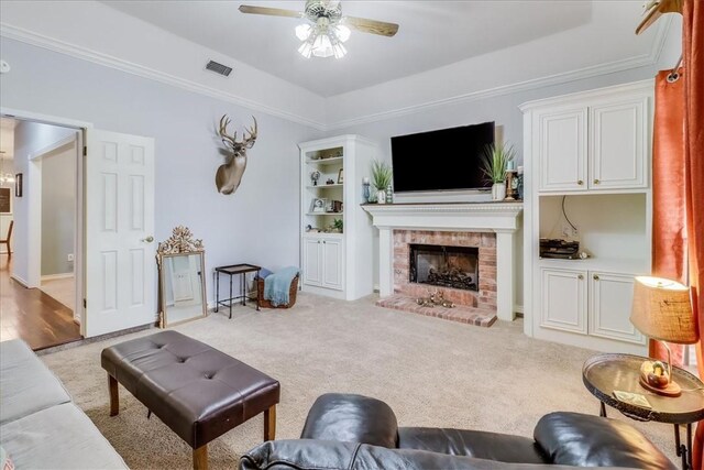 7430 Bourget Dr, Corpus Christi, TX 78413 - living area featuring a ceiling fan, light carpet, a brick fireplace, a tray ceiling, and crown molding