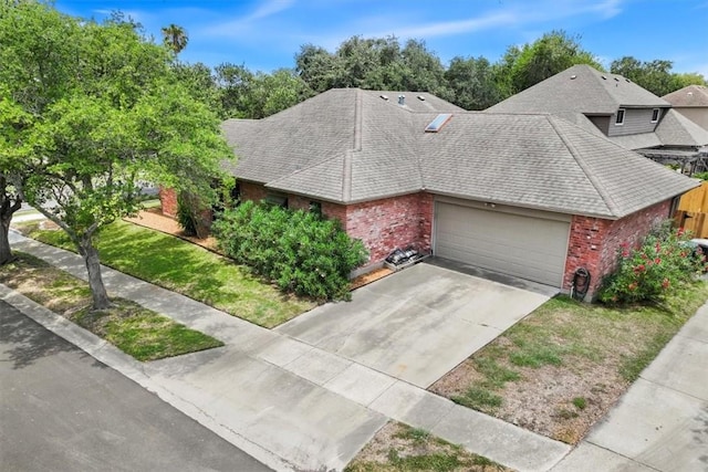 7430 Bourget Dr, Corpus Christi, TX 78413 - view of front facade featuring brick siding, an attached garage, a shingled roof, and concrete driveway