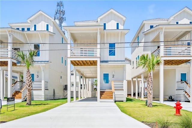 beach home with a standing seam roof, a front yard, board and batten siding, and metal roof