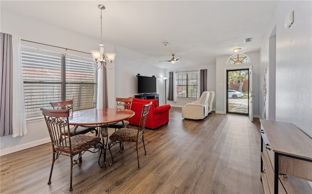 dining space with wood finished floors, visible vents, and baseboards