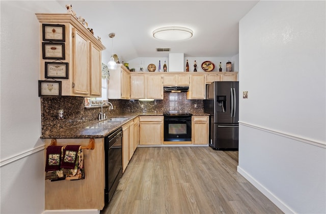 kitchen featuring tasteful backsplash, under cabinet range hood, light brown cabinetry, black appliances, and a sink