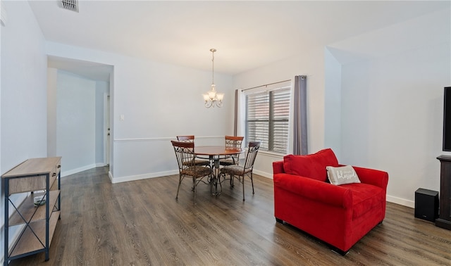 dining space with baseboards, visible vents, a chandelier, and wood finished floors