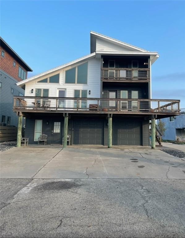 236 Dolphin Ln, Port Aransas, TX 78373 - view of front facade with an attached garage, concrete driveway, and a balcony
