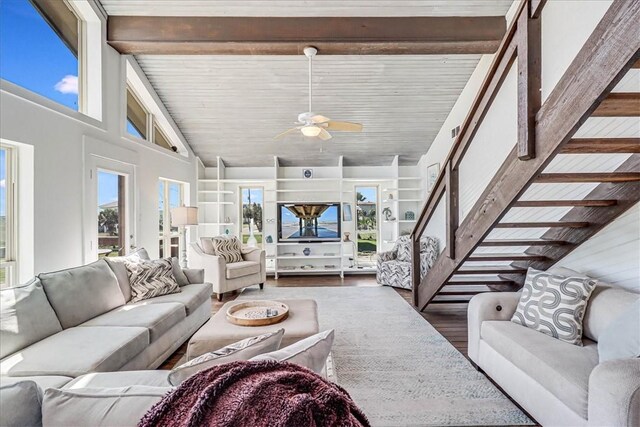 236 Dolphin Ln, Port Aransas, TX 78373 - living area with wood finished floors, a ceiling fan, high vaulted ceiling, beamed ceiling, and stairway