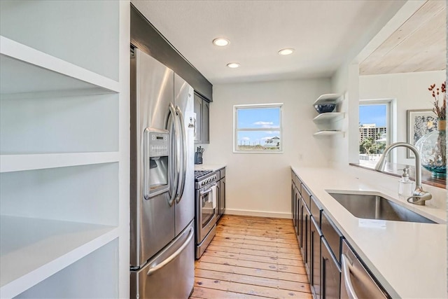236 Dolphin Ln, Port Aransas, TX 78373 - kitchen featuring a sink, stainless steel appliances, light wood finished floors, light countertops, and open shelves