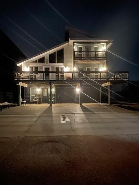 236 Dolphin Ln, Port Aransas, TX 78373 - back of house at night featuring a balcony