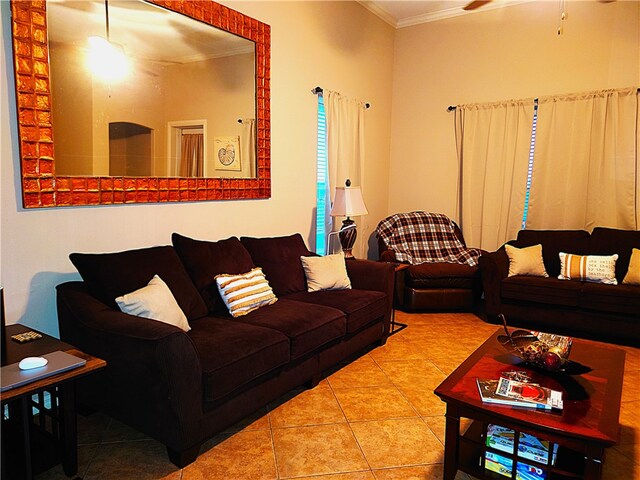 tiled living room with ceiling fan and crown molding