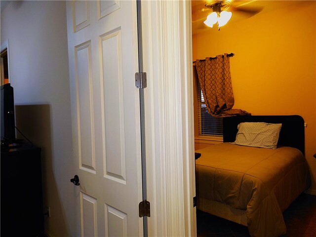 bedroom with dark tile patterned flooring and ceiling fan