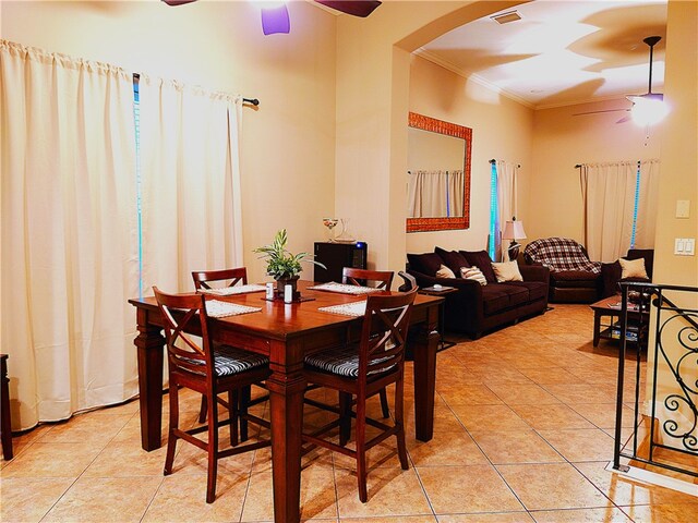 tiled dining area featuring ceiling fan and crown molding