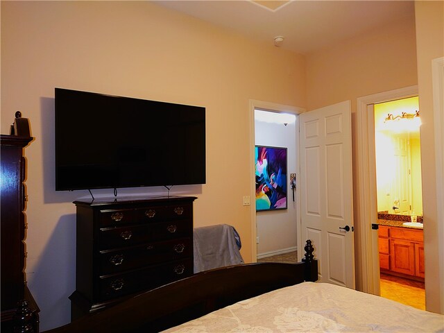 bedroom with ensuite bathroom and sink