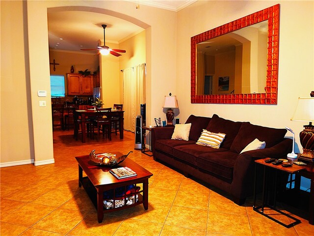 tiled living room with ornamental molding and ceiling fan