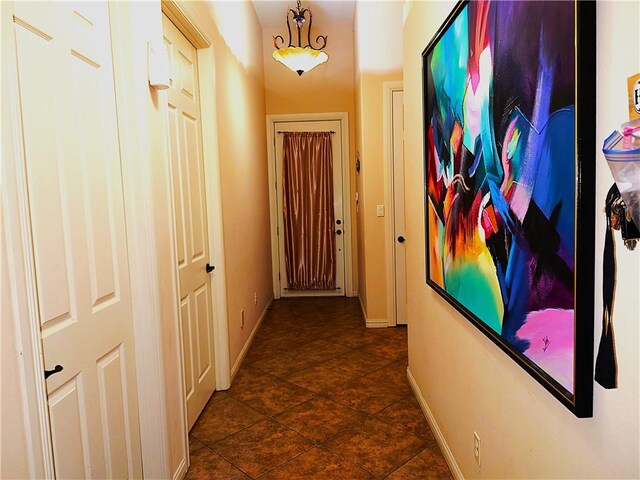 hall featuring dark tile patterned floors