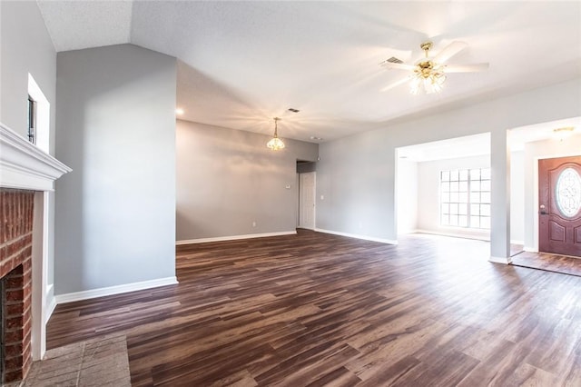 unfurnished living room with a ceiling fan, a brick fireplace, baseboards, and dark wood-style flooring