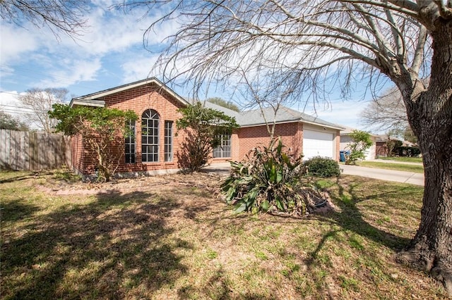 ranch-style home with an attached garage, brick siding, fence, driveway, and a front lawn