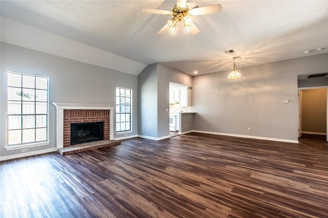 unfurnished living room with ceiling fan, dark wood-style flooring, a fireplace, baseboards, and vaulted ceiling