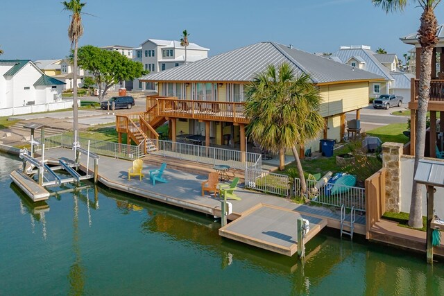 dock area featuring a residential view, a deck with water view, fence, and stairway