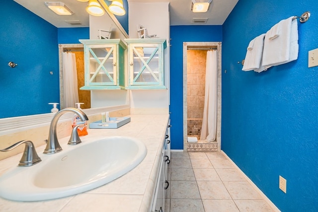 full bathroom with a sink, visible vents, a shower stall, tile patterned floors, and double vanity