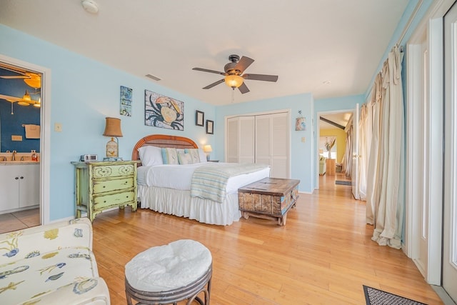 bedroom with a closet, visible vents, a sink, and light wood-style flooring