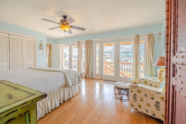 bedroom with a closet, access to outside, french doors, and light wood-style flooring