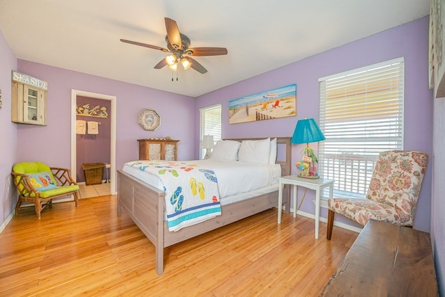 bedroom featuring light wood-type flooring, multiple windows, and baseboards