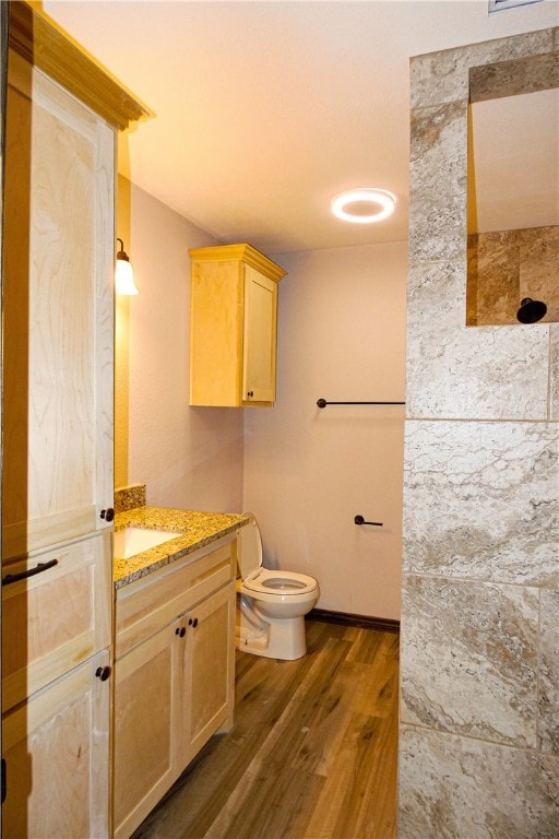 bathroom with toilet, vanity, and hardwood / wood-style flooring