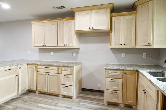 kitchen featuring light brown cabinetry and light hardwood / wood-style flooring