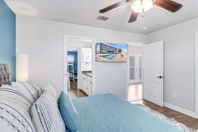 bedroom featuring ceiling fan, light hardwood / wood-style flooring, and ensuite bathroom