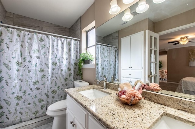 full bath with a ceiling fan, vanity, a shower with curtain, toilet, and visible vents