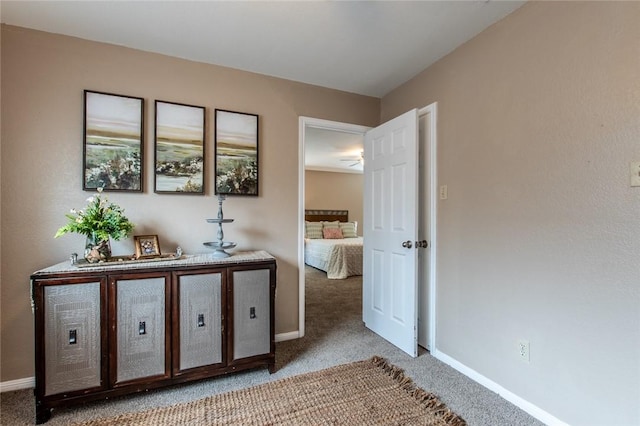 hallway featuring baseboards and light colored carpet