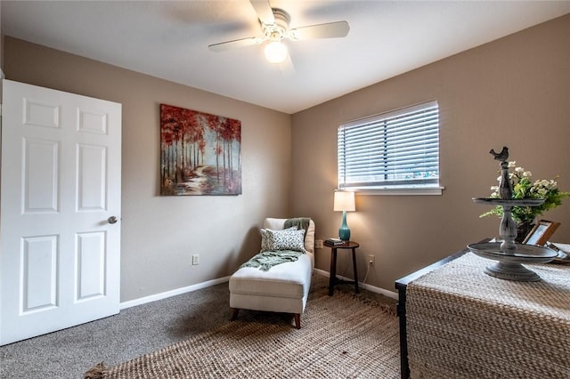 living area featuring baseboards, a ceiling fan, and carpet flooring