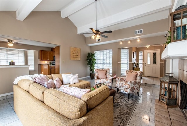 living area featuring light tile patterned flooring, visible vents, beam ceiling, and ceiling fan