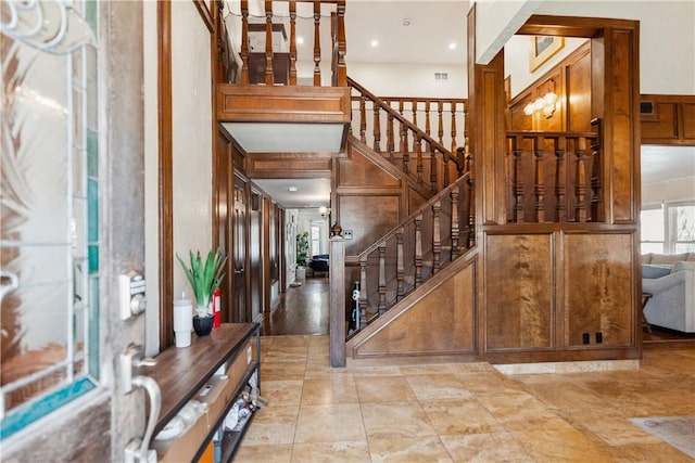 entrance foyer featuring stairway, visible vents, and a towering ceiling