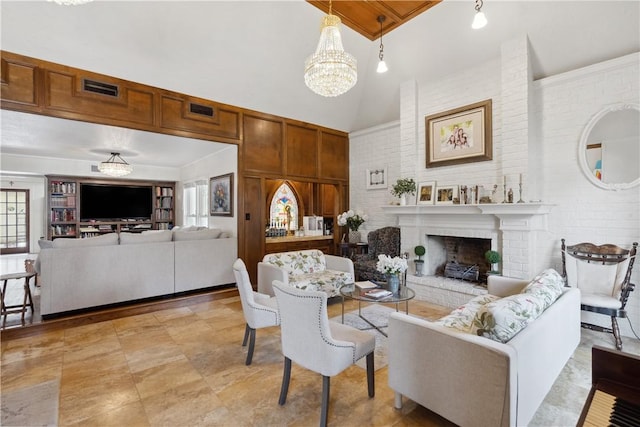 living room with visible vents, a high ceiling, brick wall, a fireplace, and a chandelier