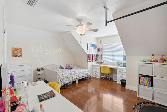 bedroom featuring visible vents, vaulted ceiling, hardwood / wood-style flooring, a textured ceiling, and a ceiling fan