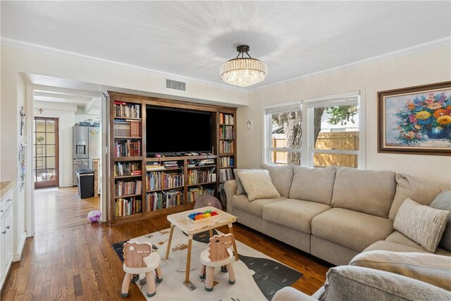 living area featuring crown molding, wood finished floors, visible vents, and a healthy amount of sunlight