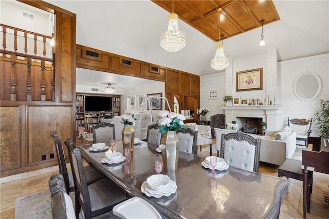 dining area with visible vents, high vaulted ceiling, a fireplace, and a notable chandelier