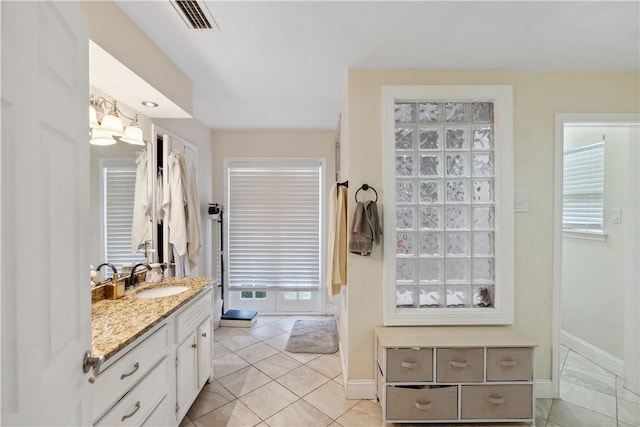 bathroom featuring tile patterned floors, visible vents, baseboards, and vanity